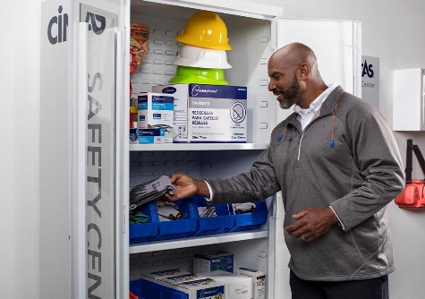 employee picking up gloves in safety center cabinet